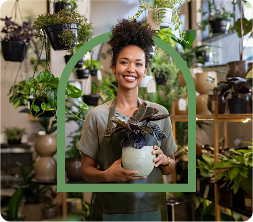 Image of female business owner holding a plant after Millbrook has helped her unlock her business' potential