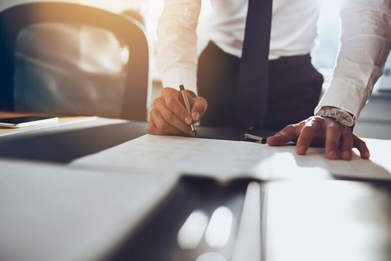 Business asset finance - Man signing contract at a desk