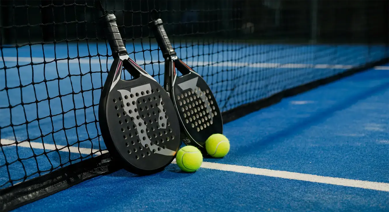 Padel rackets and balls on court, ready to play